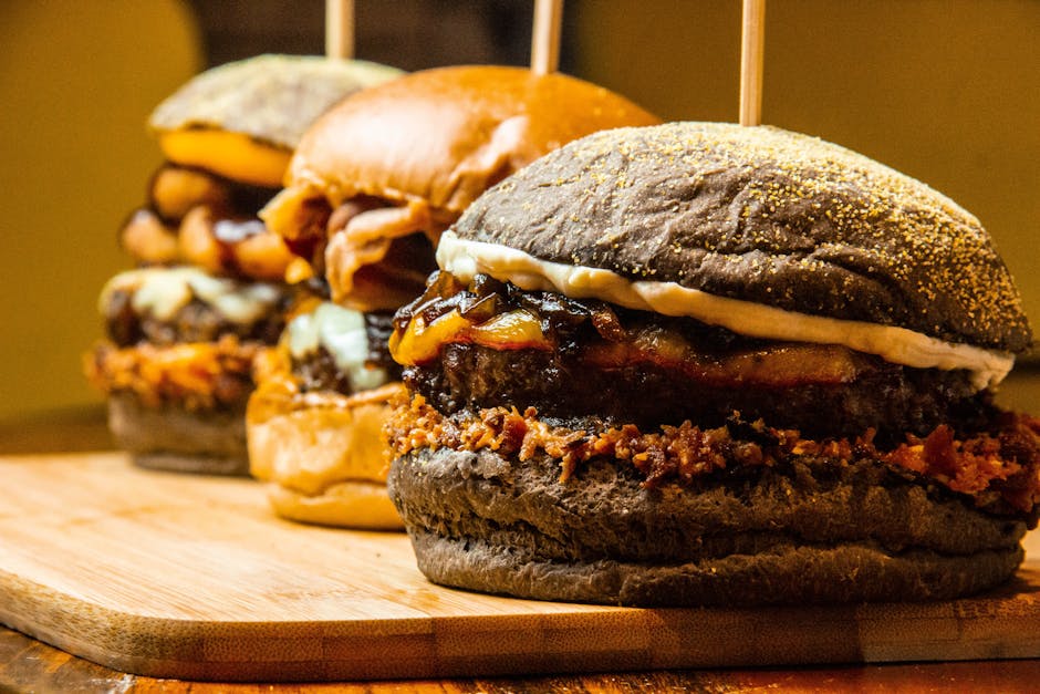 Mouthwatering close-up of gourmet burgers on a wooden board, showcasing delicious textures and toppings