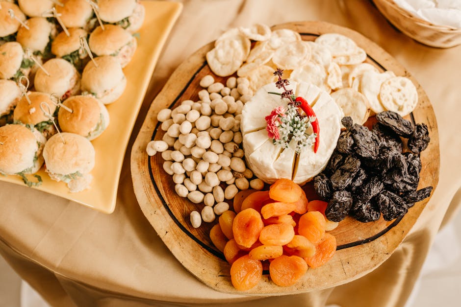 Delectable cheese board featuring snacks and gourmet mini burgers on a beige tablecloth