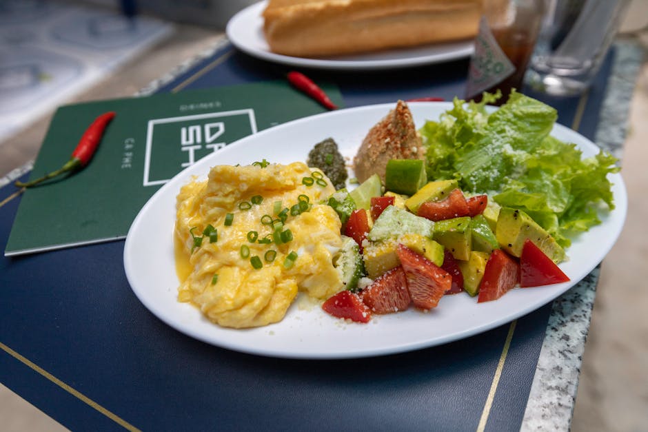 Scrumptious breakfast featuring scrambled eggs, fresh salad, and a baguette on a white plate