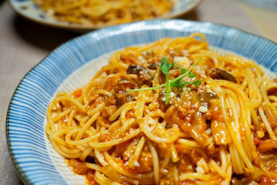 Close-up of a delicious spaghetti dish in tomato sauce with mushrooms and herbs, served in Tokyo