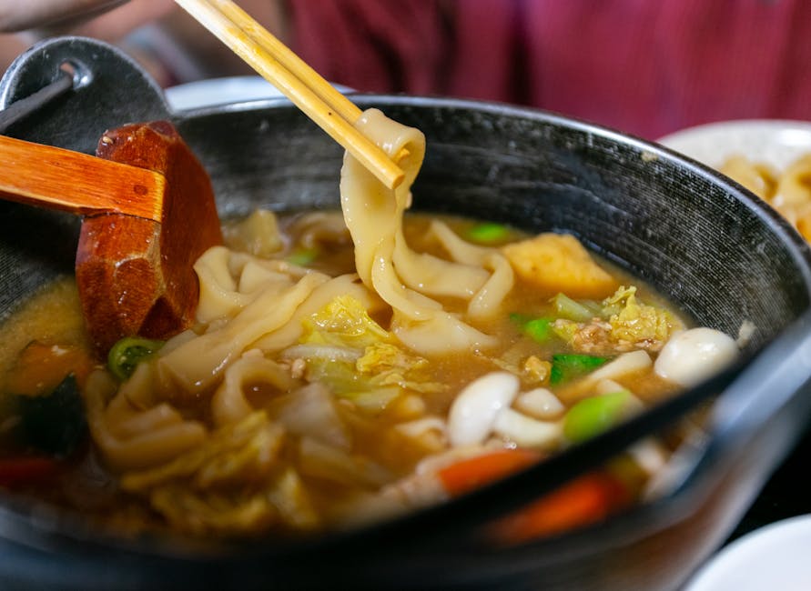 Delicious udon noodle soup with fresh vegetables and rich broth, captured up close