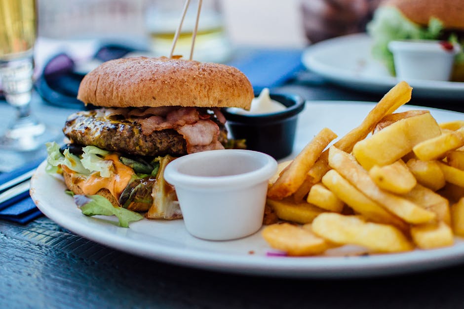 Close-up of a juicy burger and crispy fries served with sauces, perfect for a hearty meal