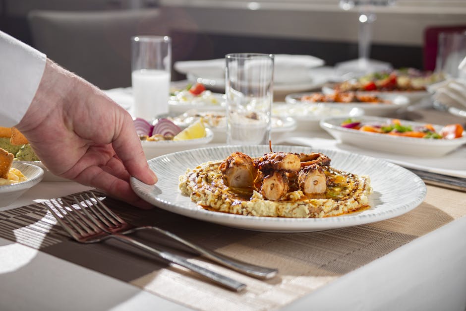 Close-up of a gourmet octopus dish being served at an elegant dining table